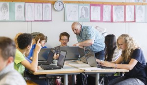 GOETTINGEN, GERMANY - SEPTEMBER 19: Posed scene: teacher supervising students who are working with laptops during a class at the Georg-Christoph-Lichtenberg-Gesamtschule IGS Goettingen on September 19, 2014, in Goettingen, Germany. The Georg-Christoph-Lichtenberg-Gesamtschule is a comprehensive school. Photo by Thomas Trutschel/Photothek via Getty Images)***Local Caption***